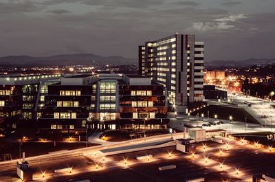 Illuminated cityscape against sky at night