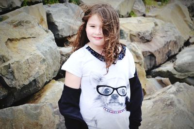 Portrait of girl standing against rocks