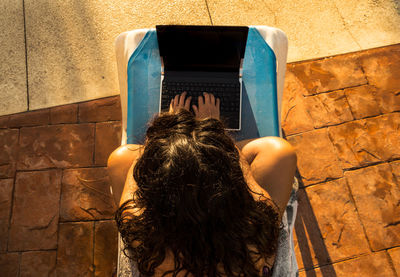 Directly above shot of woman using laptop outdoors