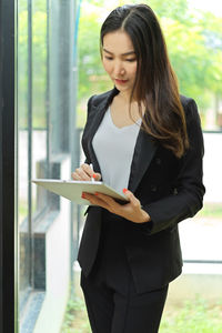 Young woman looking at camera while standing outdoors