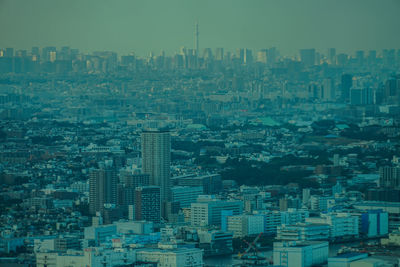 Aerial view of buildings in city against sky