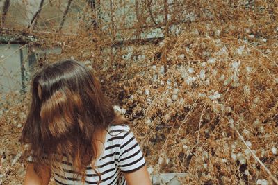 Woman with brown hair against plants