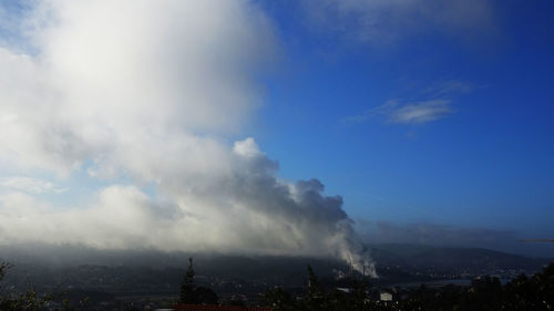 Smoke emitting from cityscape against sky