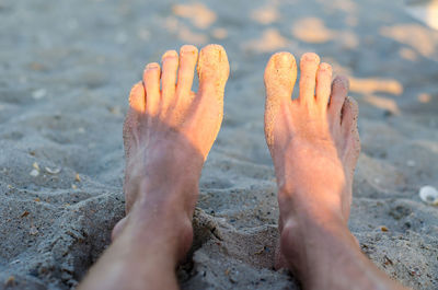 Low section of person relaxing on beach