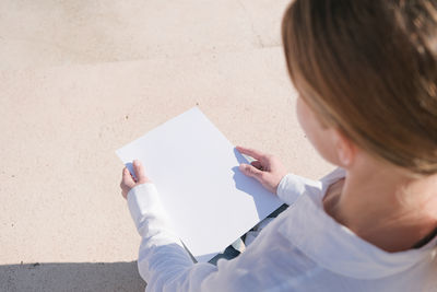 High angle view of woman writing in book