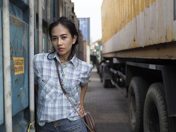 Portrait of beautiful young woman standing in city