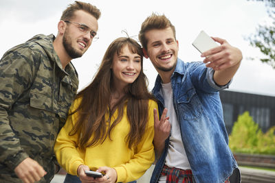 Portrait of smiling young man using smart phone