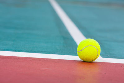 Close-up of yellow ball on tennis court