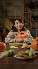 Portrait of young woman eating food on table