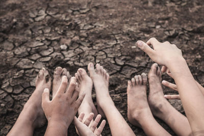 Low section of friends gesturing on drought field