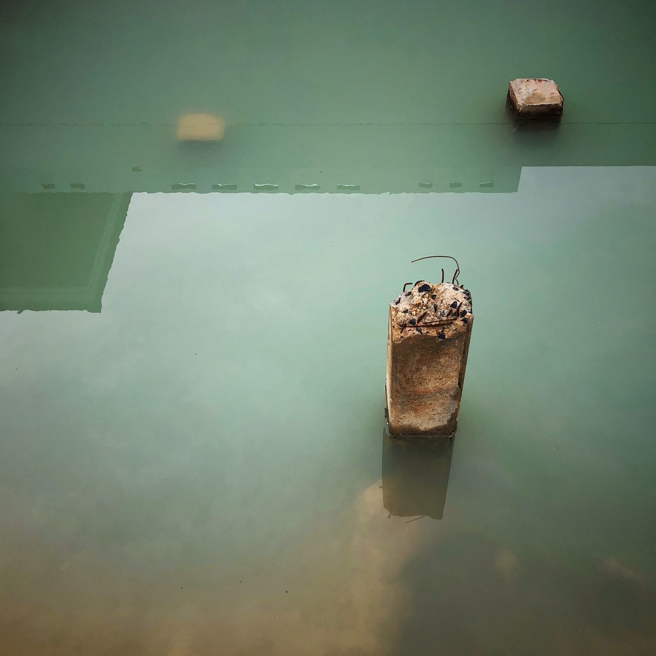 HIGH ANGLE VIEW OF METAL CONTAINER ON LAKE