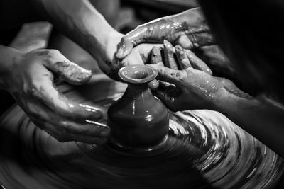 Cropped hands of people making pottery in workshop