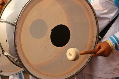 Midsection of man playing drum