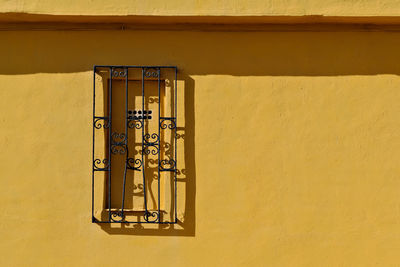 Close-up of yellow wall and metal structure