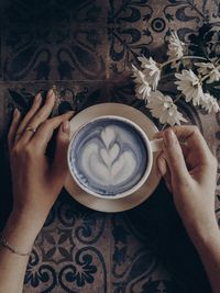 Directly above shot of woman holding coffee cup