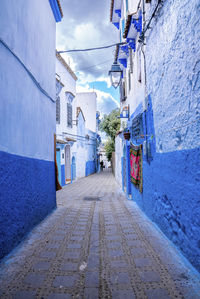 Narrow alley of blue town with residential structures on both side