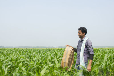 Side view of young man standing in field