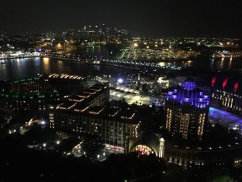 Illuminated cityscape against sky at night