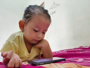 Cute girl using mobile phone at home