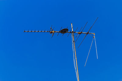 Low angle view of crane against clear blue sky