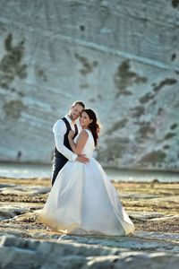 Portrait of newlywed couple standing on field