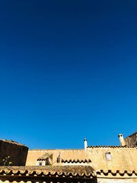 Low angle view of wall against blue sky