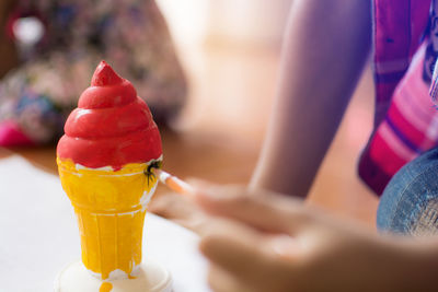 Close-up of hand holding drink on table