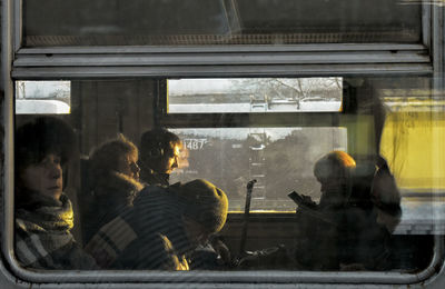 People traveling in train seen through window