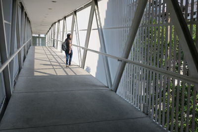 Young woman walking on elevated walkway