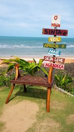 Information sign on beach against sky