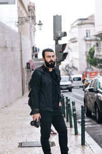 Man standing on sidewalk in city