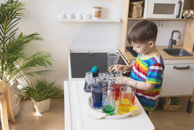 Side view of boy playing with ice cream at home