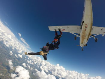Low angle view of airplane flying against sky