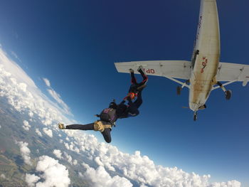 Low angle view of skydivers jumping out of airplane. skydive formation free falling from aircraft. 