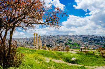 View of cityscape against cloudy sky