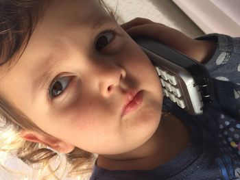 Close-up portrait of cute girl using cordless phone