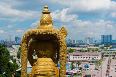 Statue of buildings in city against sky