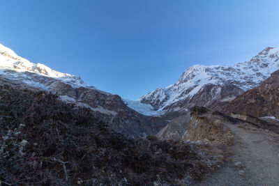 Scenic view of snowcapped mountains against clear blue sky