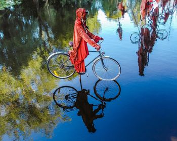 Reflection of man on bicycle in water