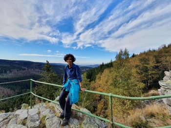 Full length of man standing on railing against sky