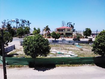 Buildings by swimming pool against clear sky