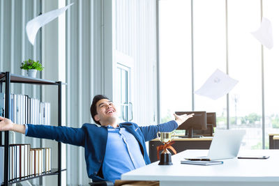 Portrait of smiling young businesswoman using digital tablet in office