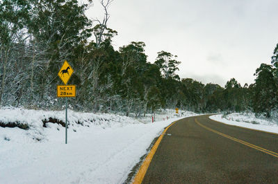 Winter landscape of countryside road warning sign of wild horses ahead