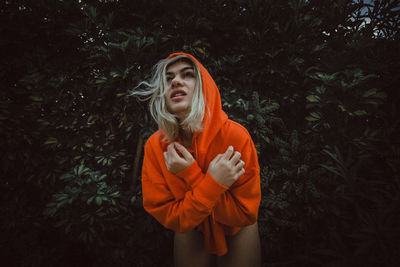 Woman in warm clothing against tree