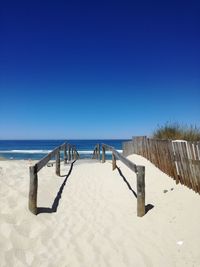 Scenic view of beach against clear blue sky