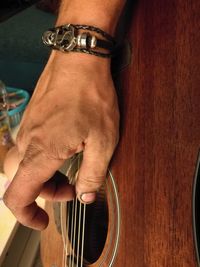 Cropped hand of musician plucking guitar strings