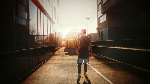 Rear view of young man on longboard