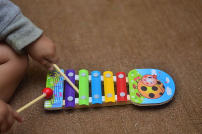 Midsection of child playing xylophone at home