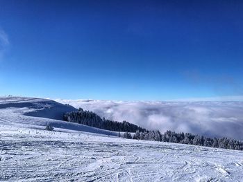 Scenic view of snow mountains against blue sky