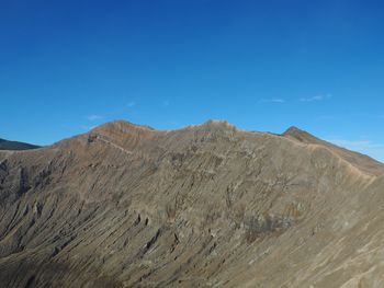 Scenic view of mountains against clear blue sky